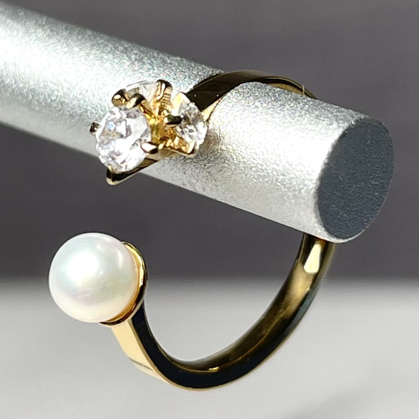 ダイヤモンドとパールが対になった、ゴールドのモダンなデザインのファッションリング