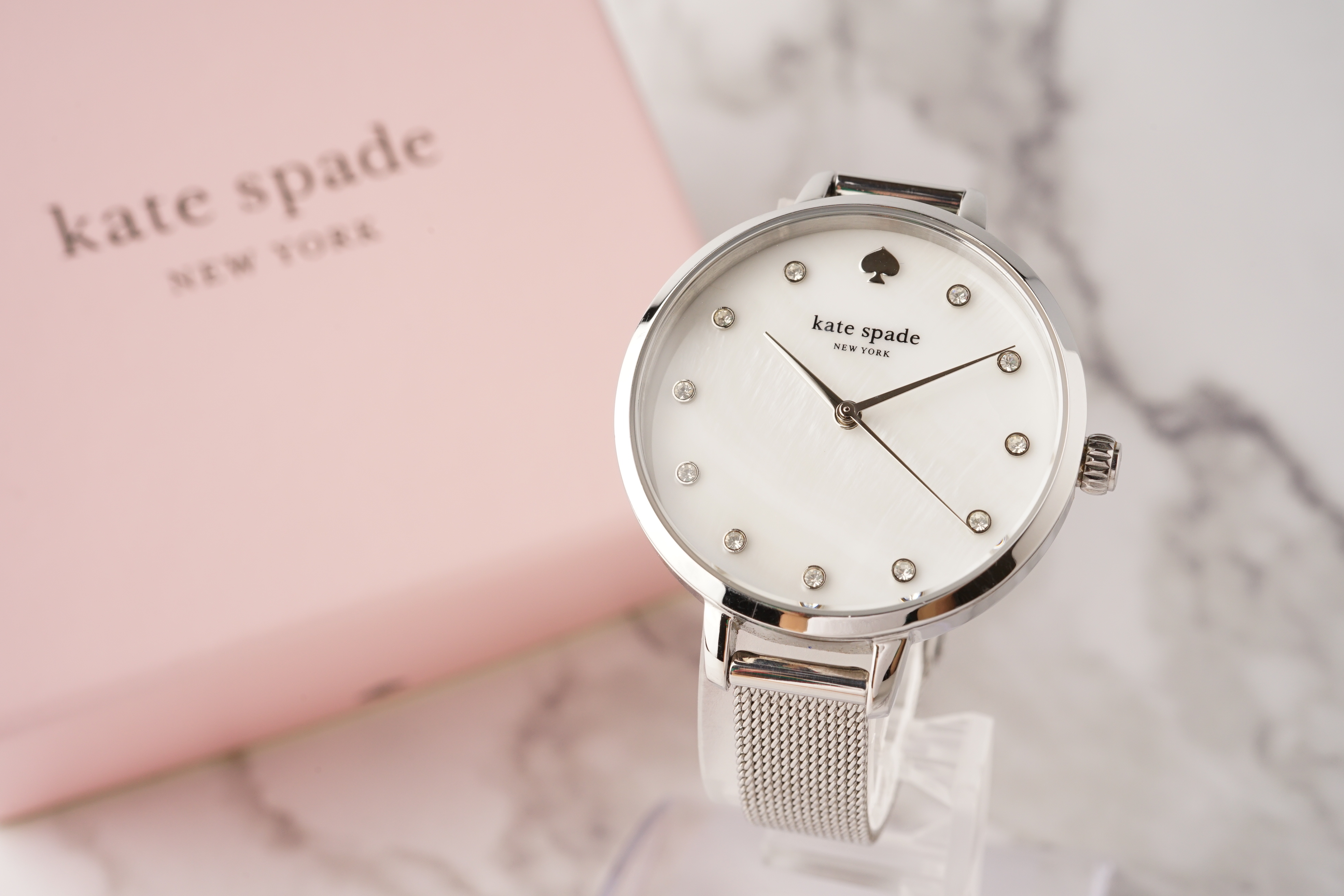 白い文字盤にクリスタルが埋め込まれた、Kate Spadeのレディース腕時計